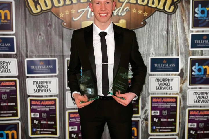 a person holding a sign posing for the camera